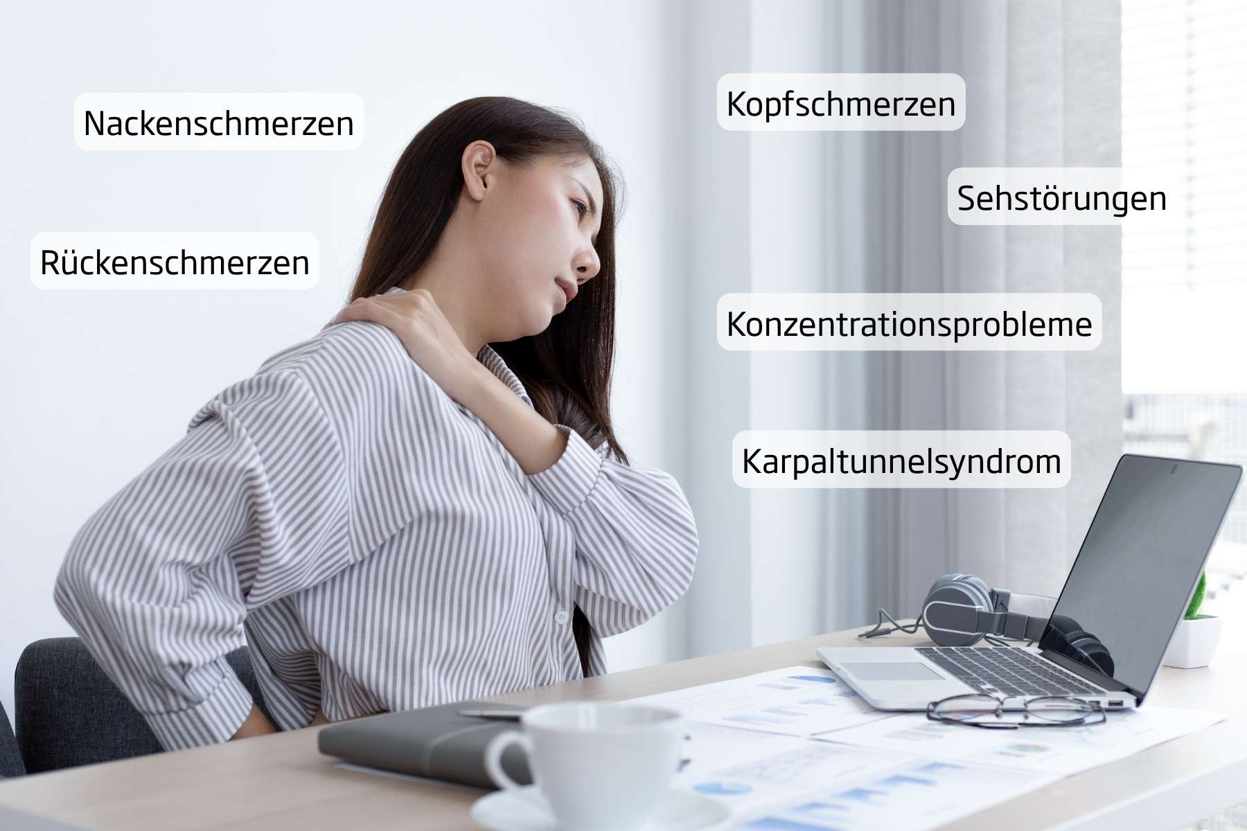 Junge Büroangestellte sitzt am Schreibtisch und verzieht das Gesicht vor Rückenschmerzen.