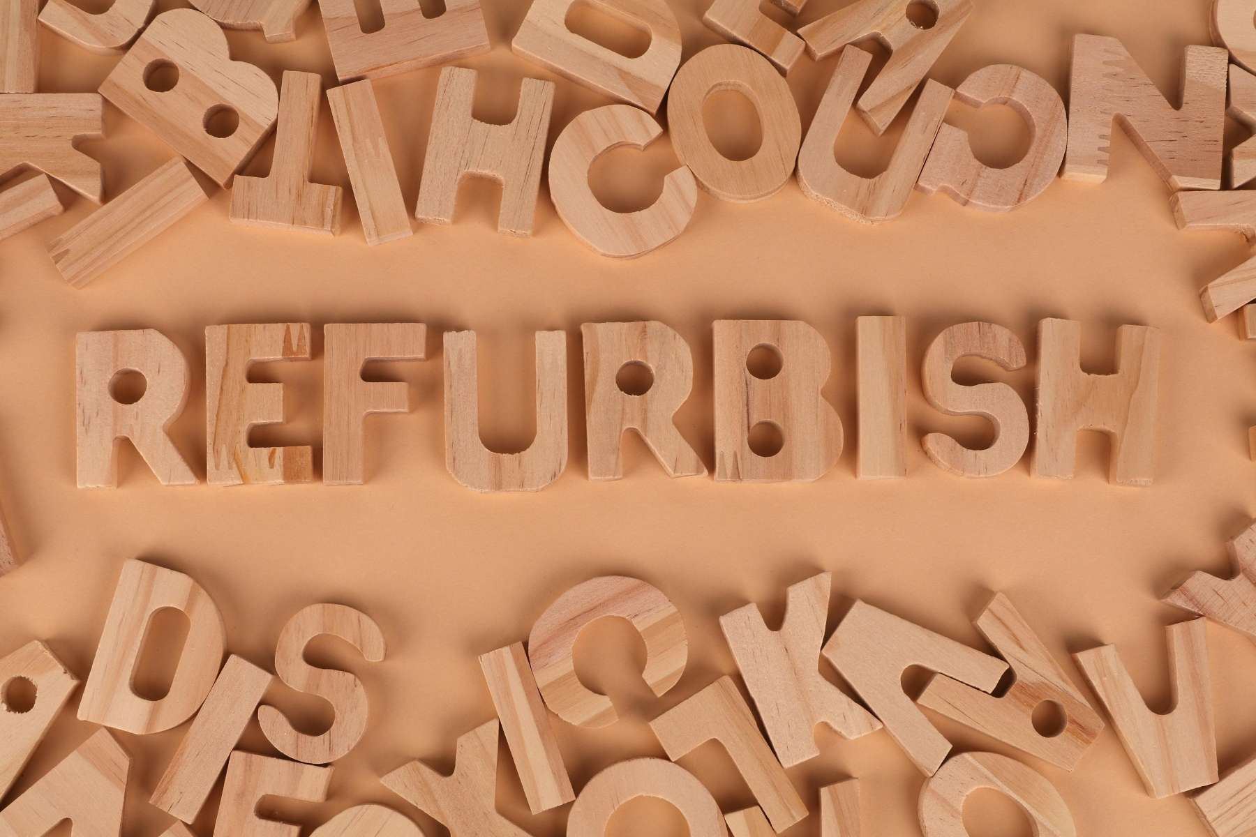 Das Wort Refurbish ist aus Holzbuchstaben zusammengesetzt während weitere Buchstaben drumherum liegen.